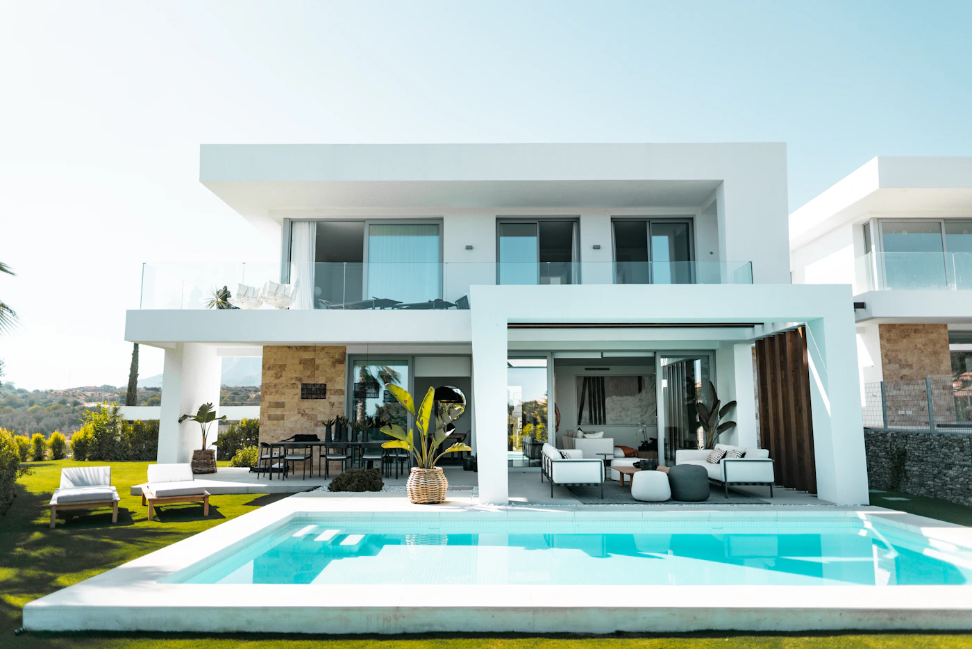 Modern white home opening onto a pool and terrace